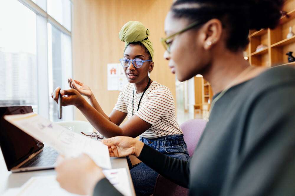Two women reviewing papers together at a desk