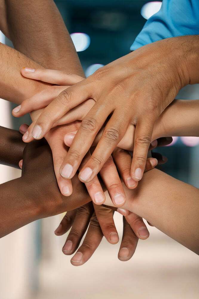 Many hands stacked together in unity