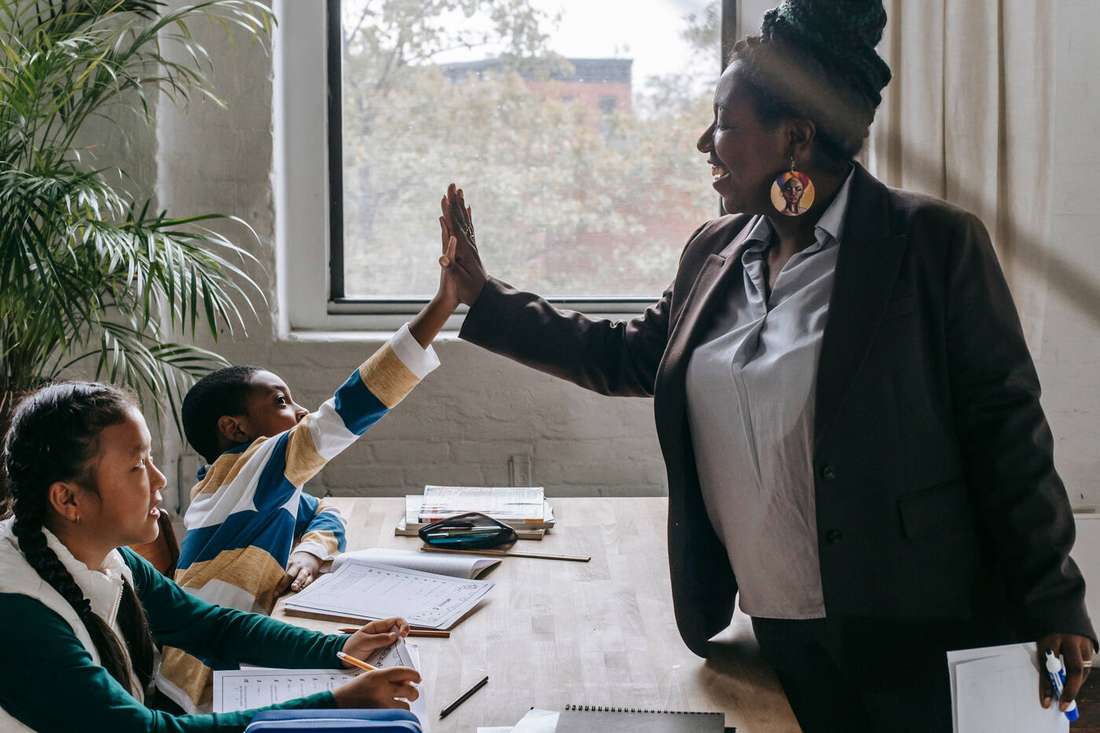 A teacher high-fiving a student during class