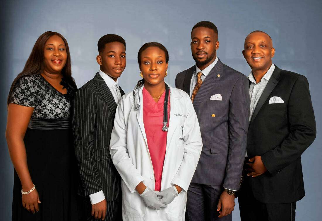 A family of professionals, including a doctor, standing proudly together