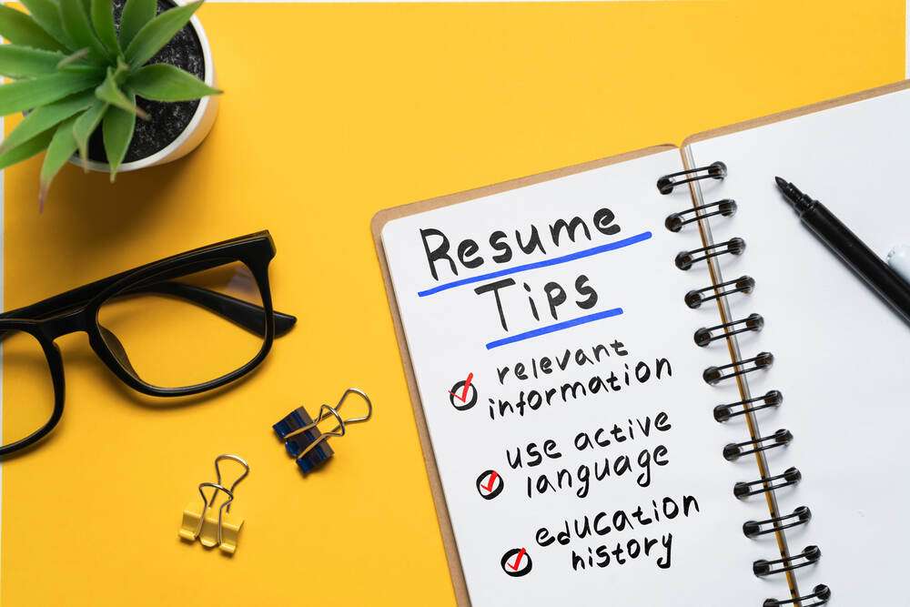 A notebook page titled Resume Tips next to glasses and a pen