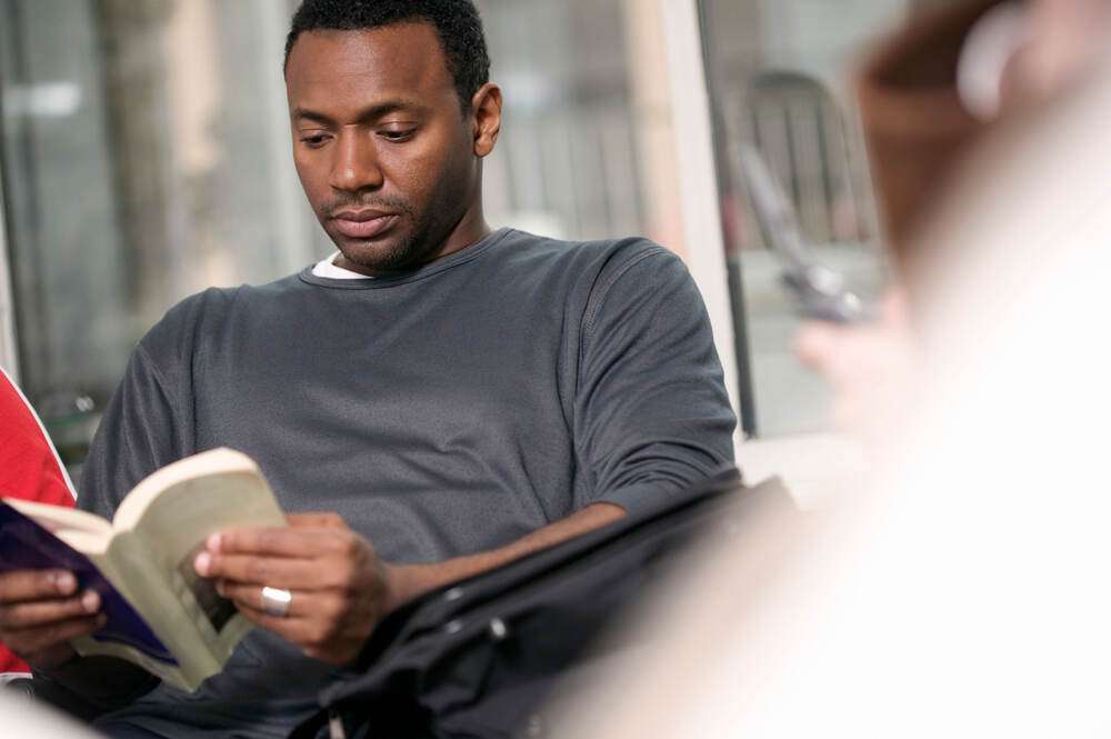 A man reading a book with focus