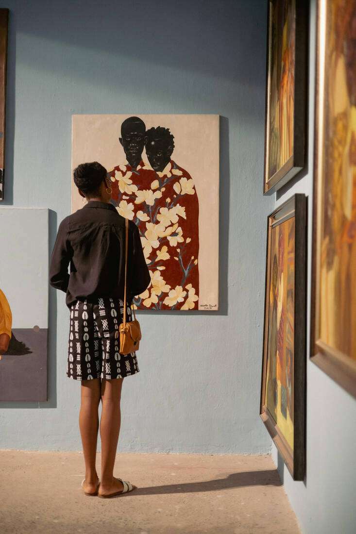 A woman viewing paintings in a gallery